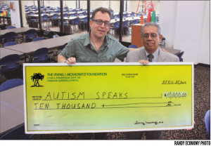 Matt Asner, Chairman of California Autism Speaks receives a $10,000 check from Sal Flores of the Moskowitz Foundation last week at the Hawaiian Gardens Bingo Club.