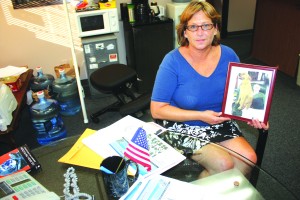 Evelyn Hileman poises with a photo of her late father Michael Henry Gregory while attending an interview in the newsroom of Hews Media Group-Community Newspaper.