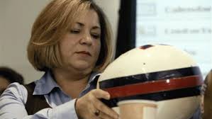 Rep. Linda T. Sanchez inspects football helmet in a former hearing on Capitol Hill in Washington, DC.